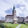 Burg Güssing Burgenland, mit einem Turm und einer Spitze darauf, umgeben von Gras.
Region NEOS das neue Österreich.